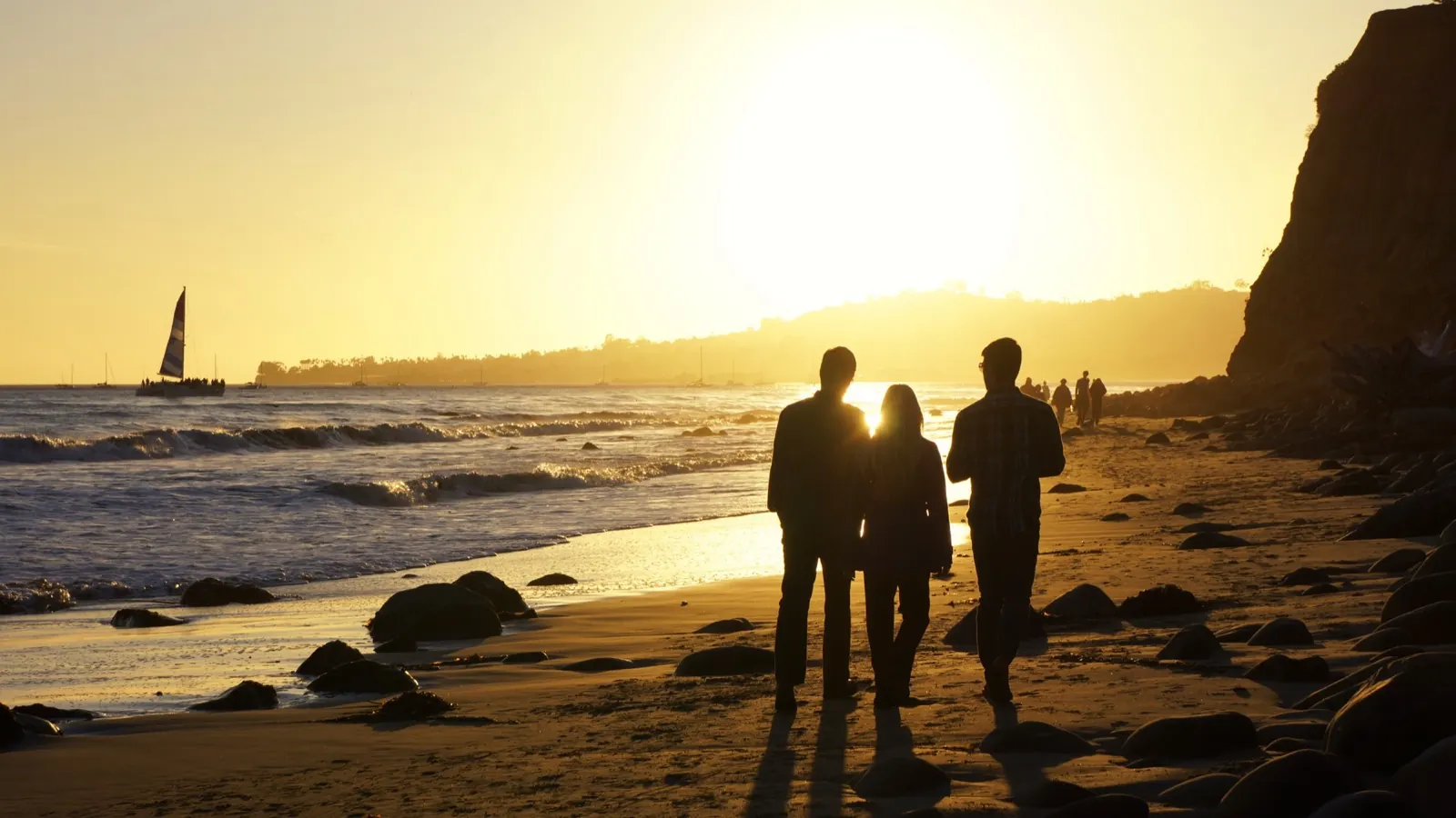 Grupo de amigos a contraluz en la playa al atardecer